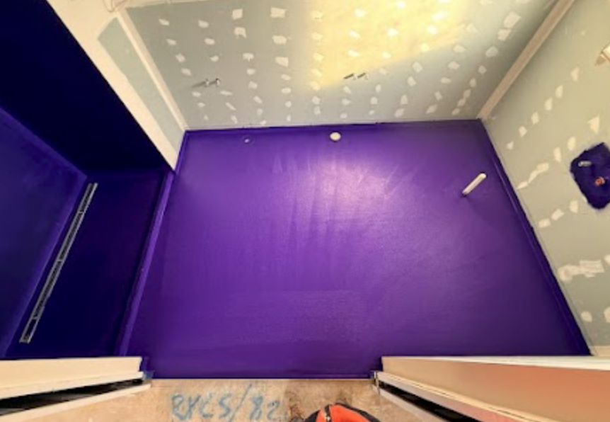 Overhead view of purple waterproofing membrane applied to shower floor and walls in Glen Waverley — Casey Quality Coatings AS 3740 certified