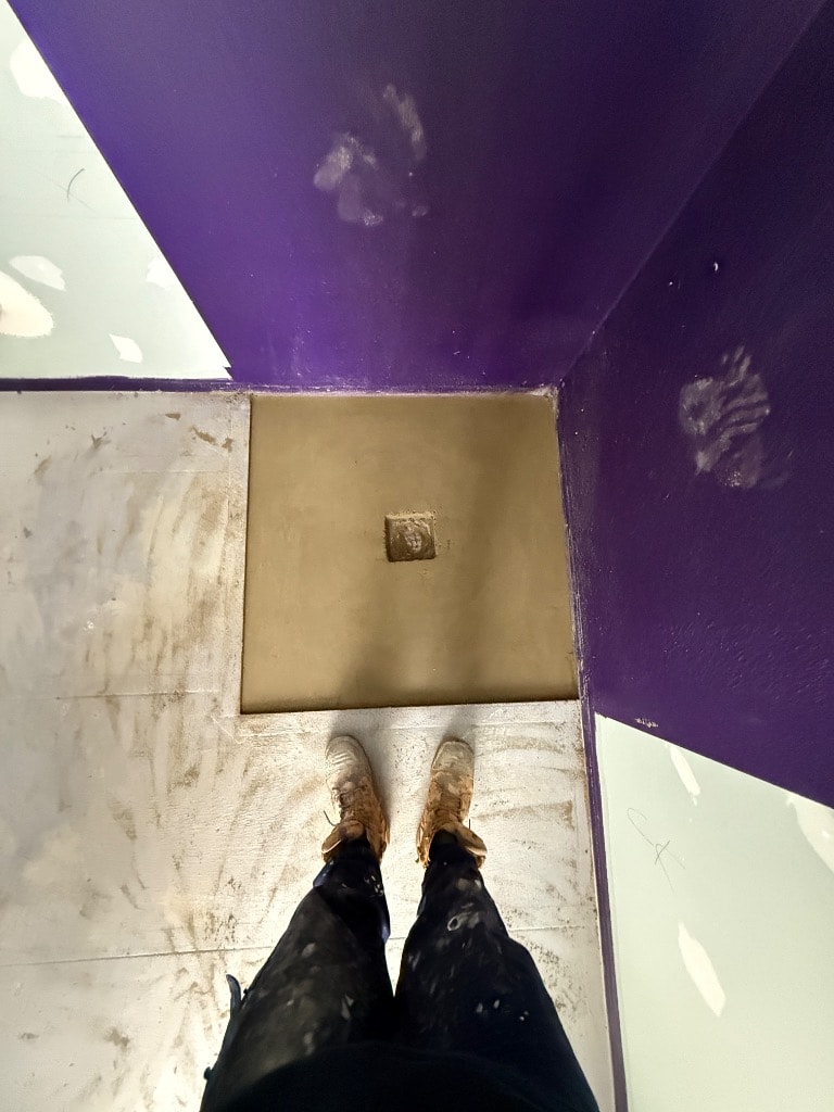 Finished shower base screed with waste set and purple waterproofing membrane on walls — Mount Waverley by Casey Quality Coatings